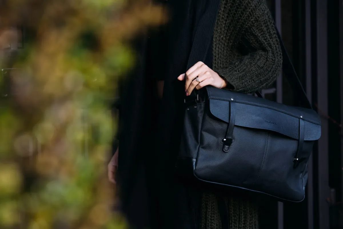 Leather messenger bag carried over the shoulder on a city street
