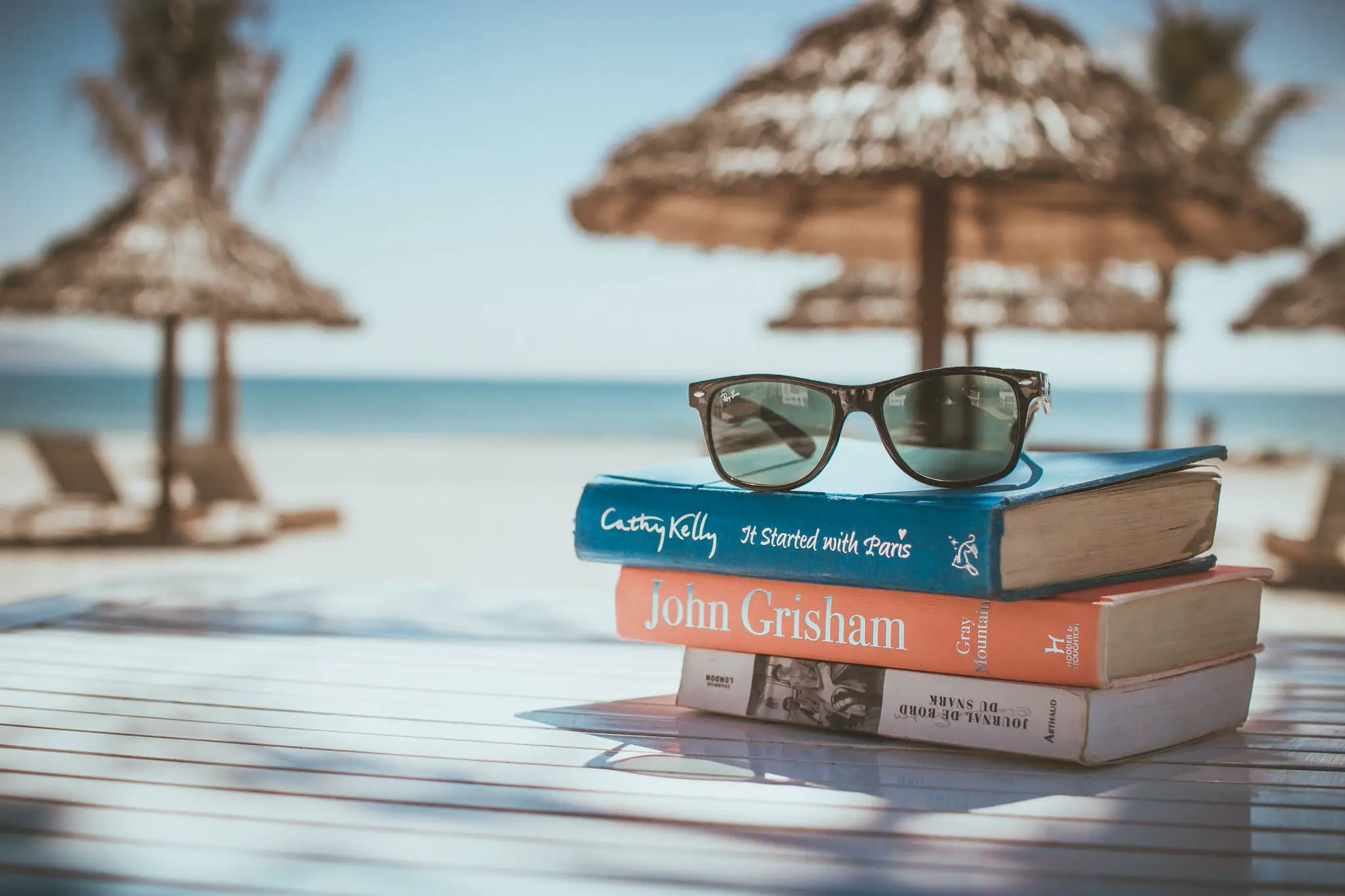 books at the beach with sunglasses on top