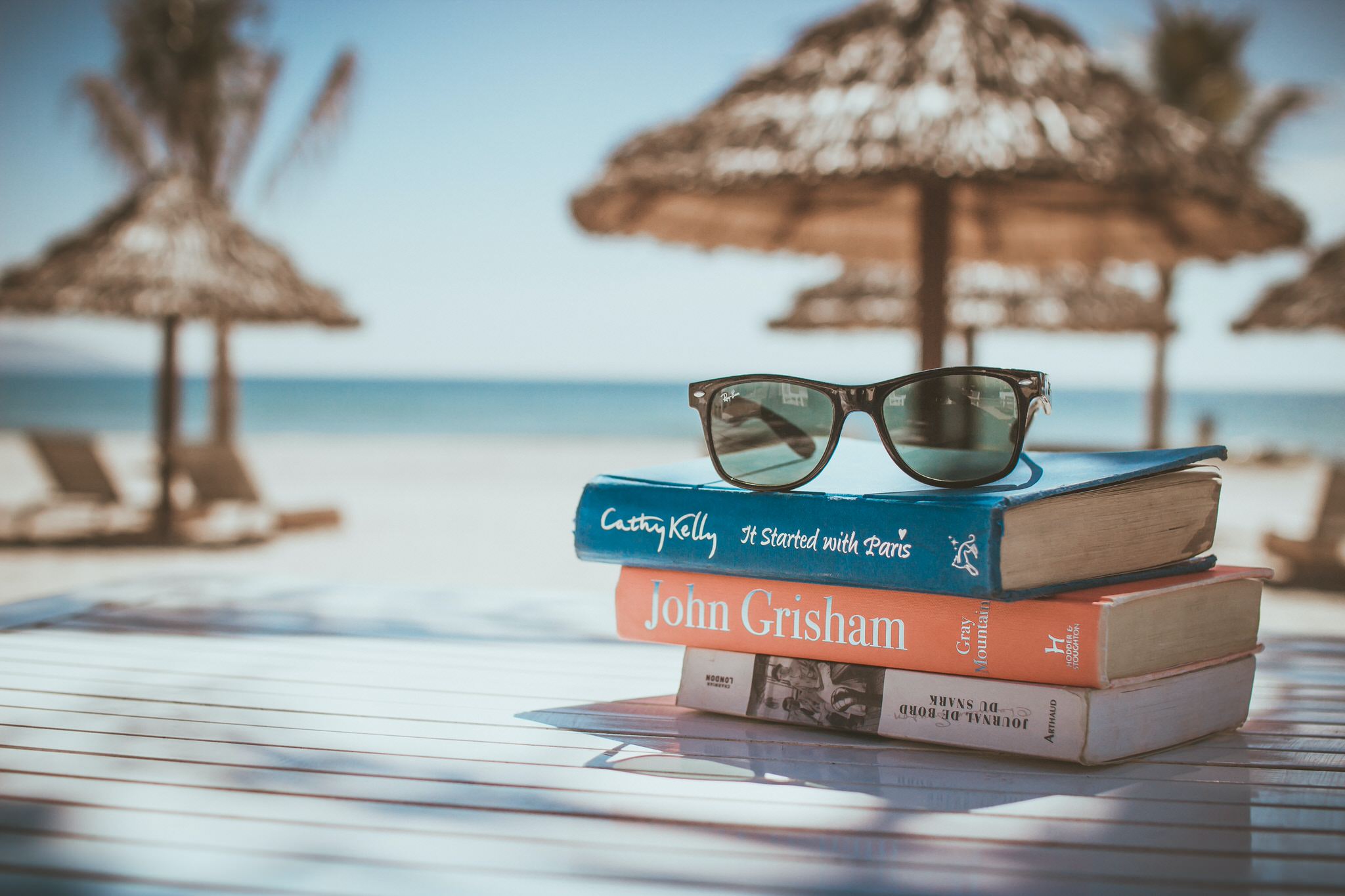 books at the beach with sunglasses on top