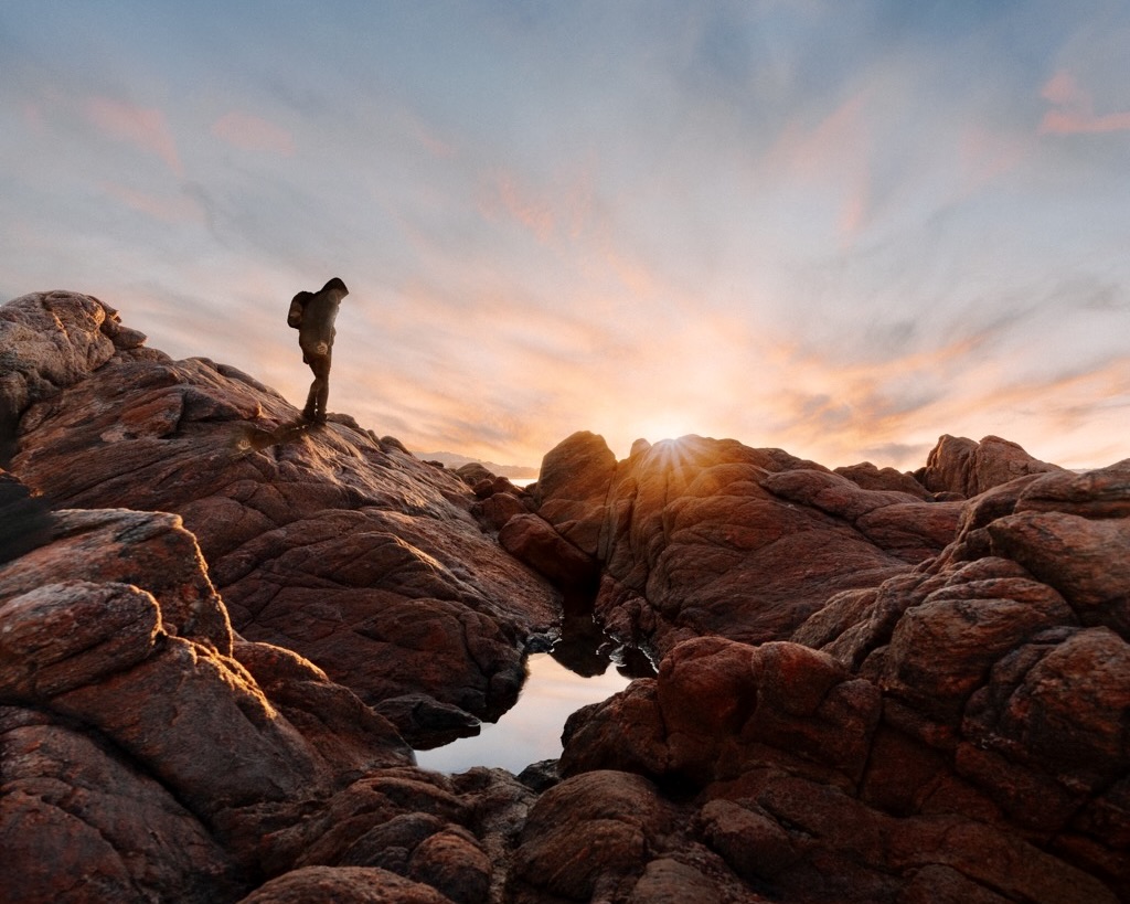 traveling through mountains with a backpack at sunset