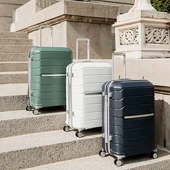Three Freeform suitcases lined up green white blue