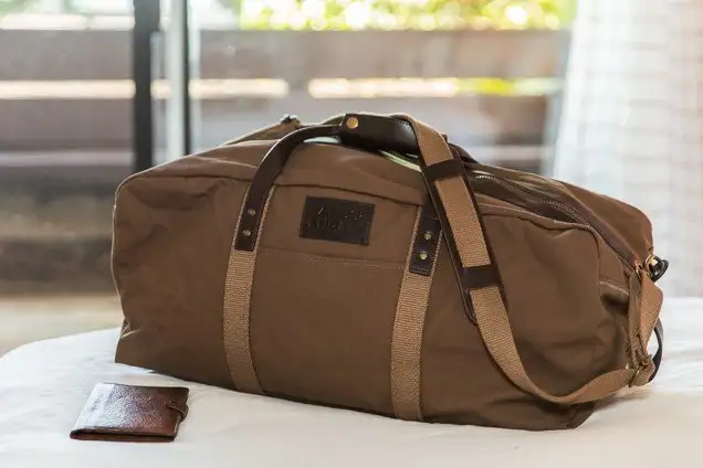 canvas tan bag on bed