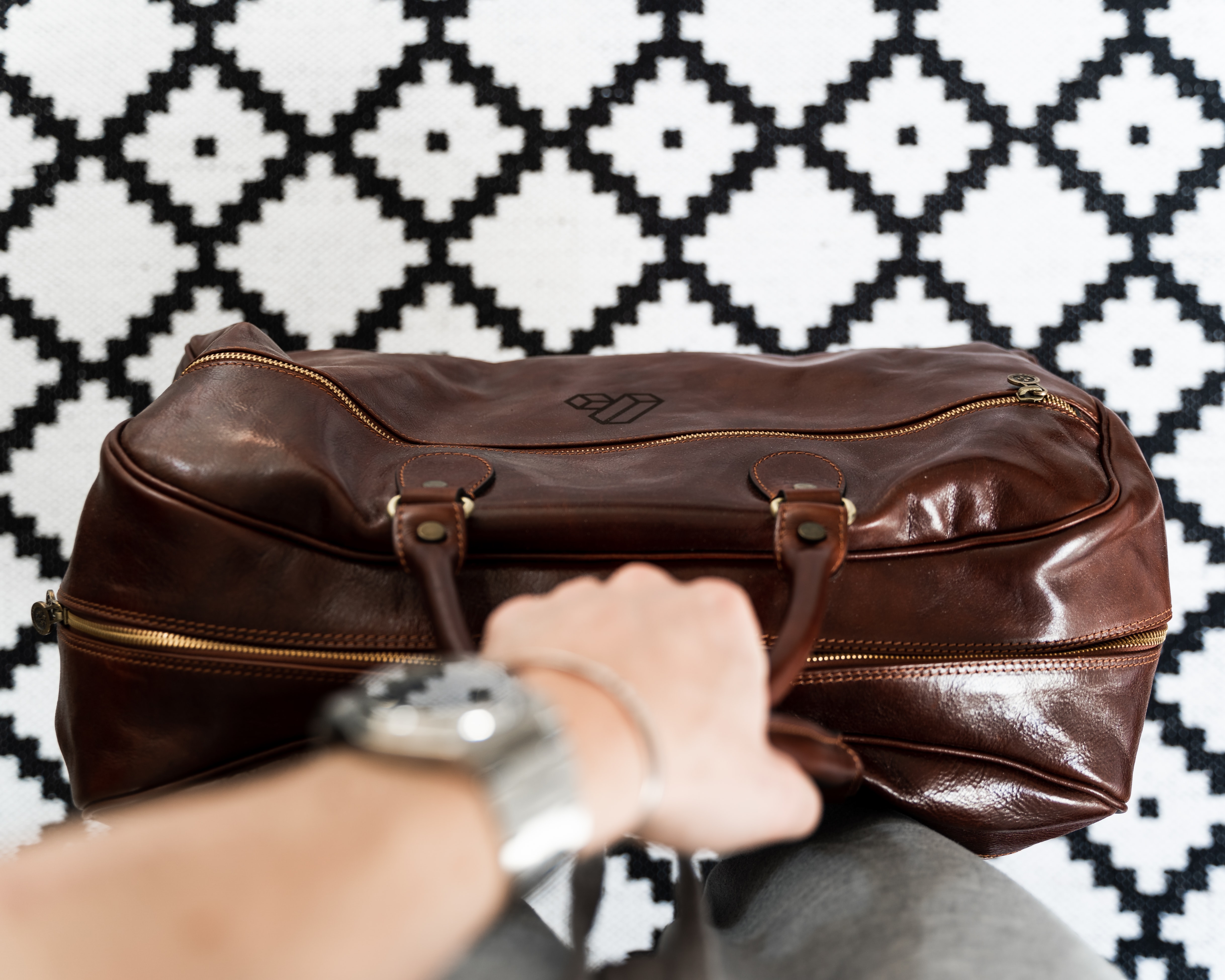 leather weekender bag being held by man