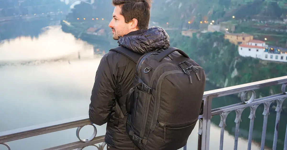 man looking over mountain with polyester backpack