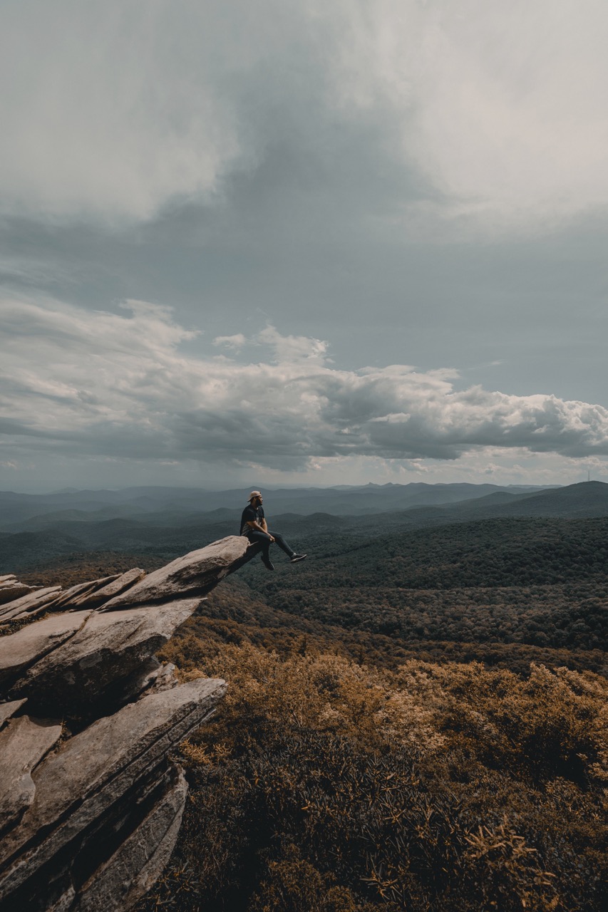 man hanging out on edge of cliff