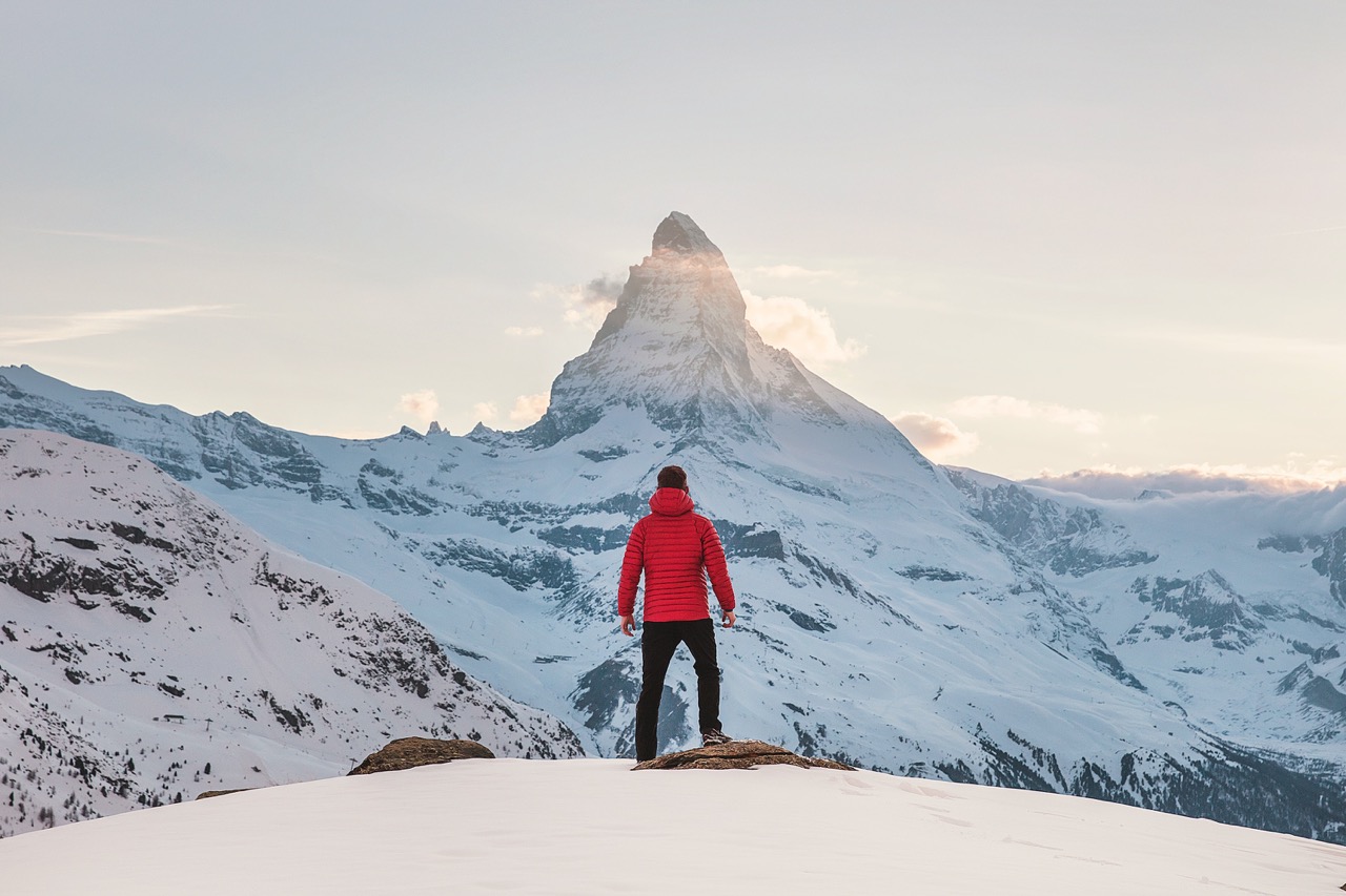 man hiking through the snow with no backpack