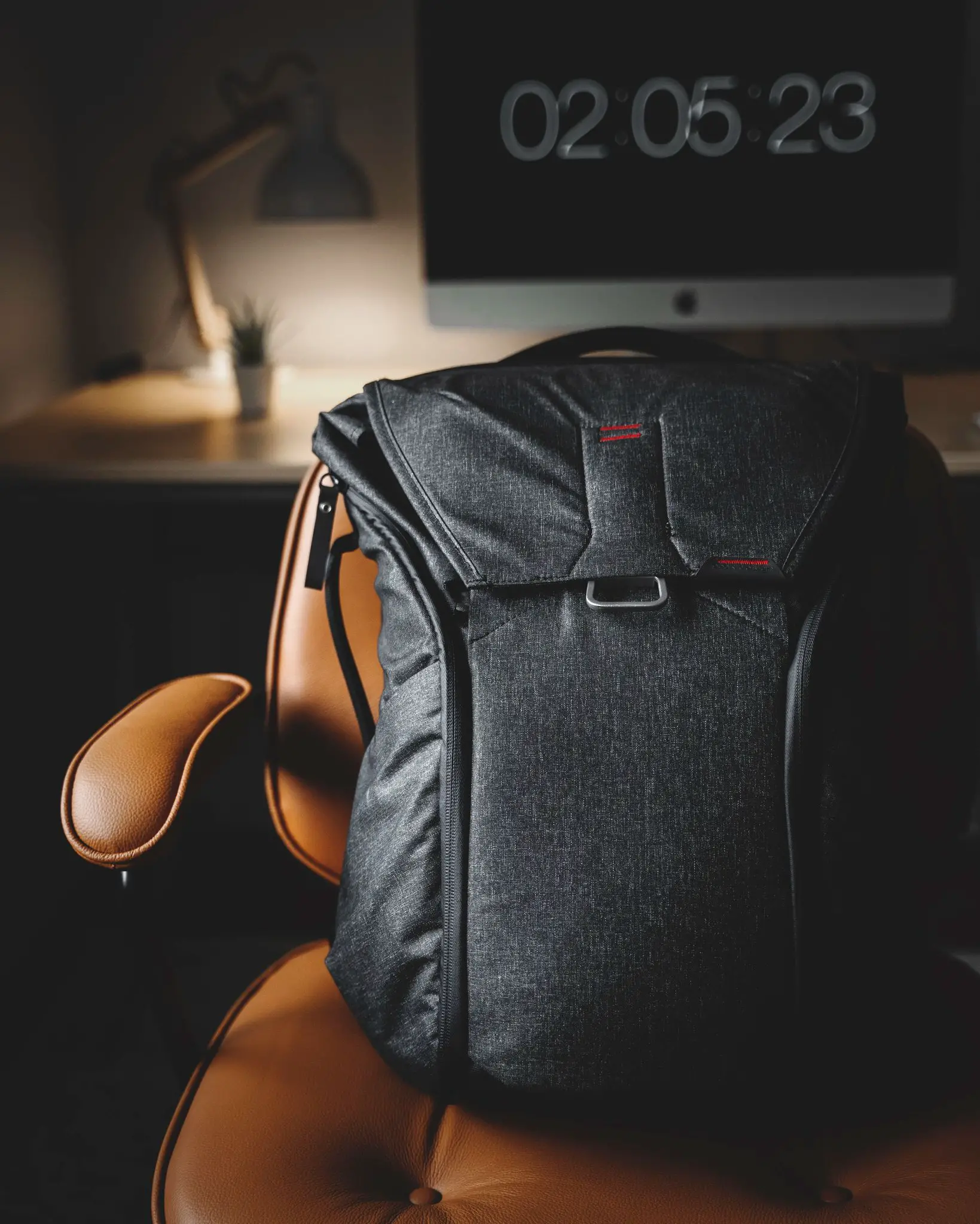 minimalist backpack sitting on a chair peak design
