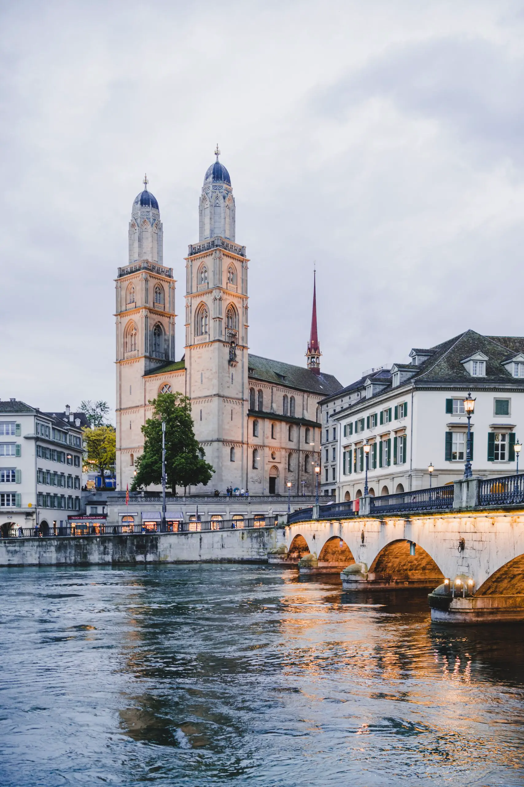 A view of the Grossmünster church in Zurich, Switzerland. The church has two twin towers and is located on the banks of the Limmat river.