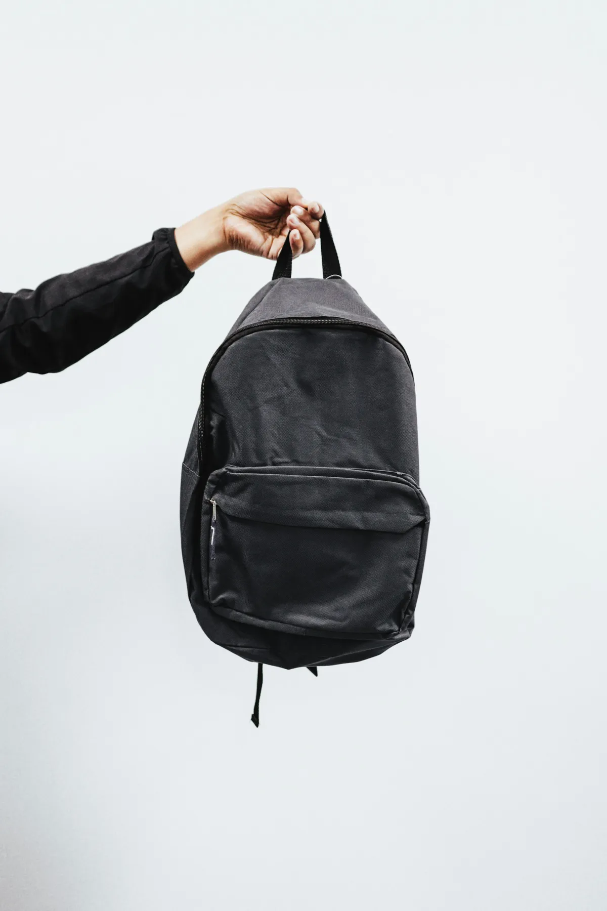 Person holding minimalist black backpack