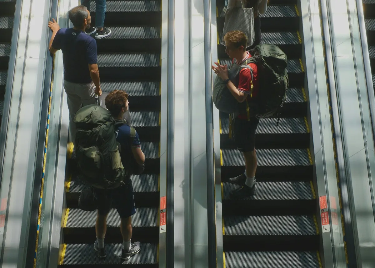 Backpackers with large travel packs on escalator