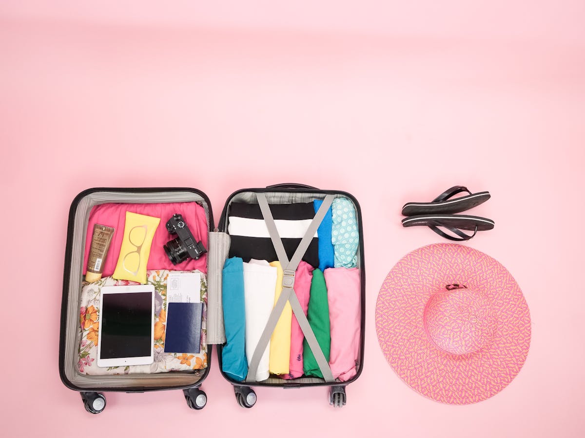 Open suitcase packed neatly with folded clothes and travel essentials ready for a trip