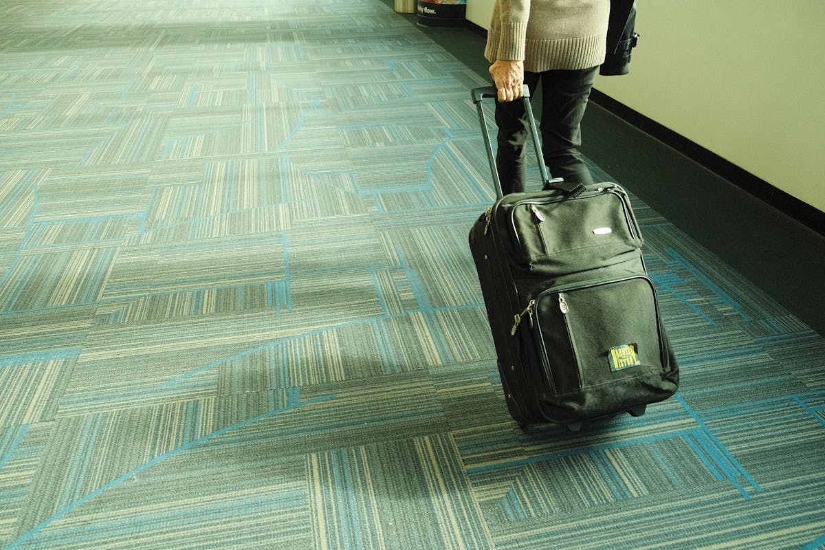 Traveler walking through airport corridor with luggage
