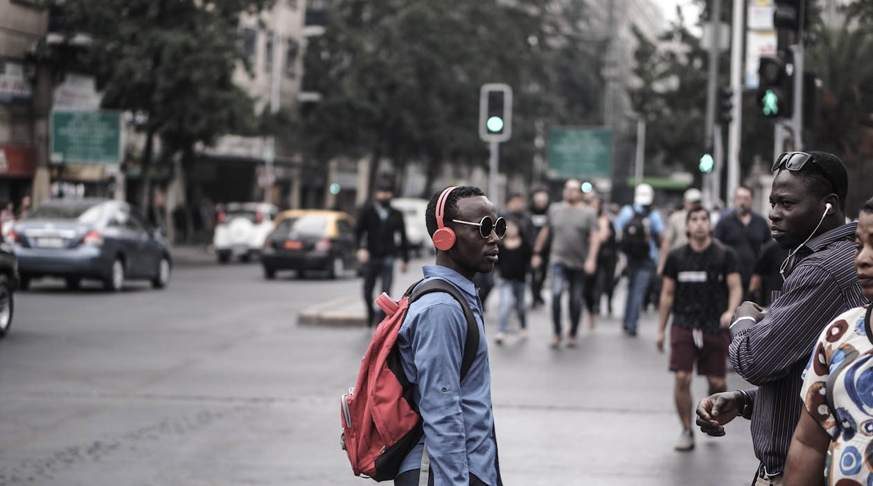 Pedestrians crossing a busy city street with bags and briefcases