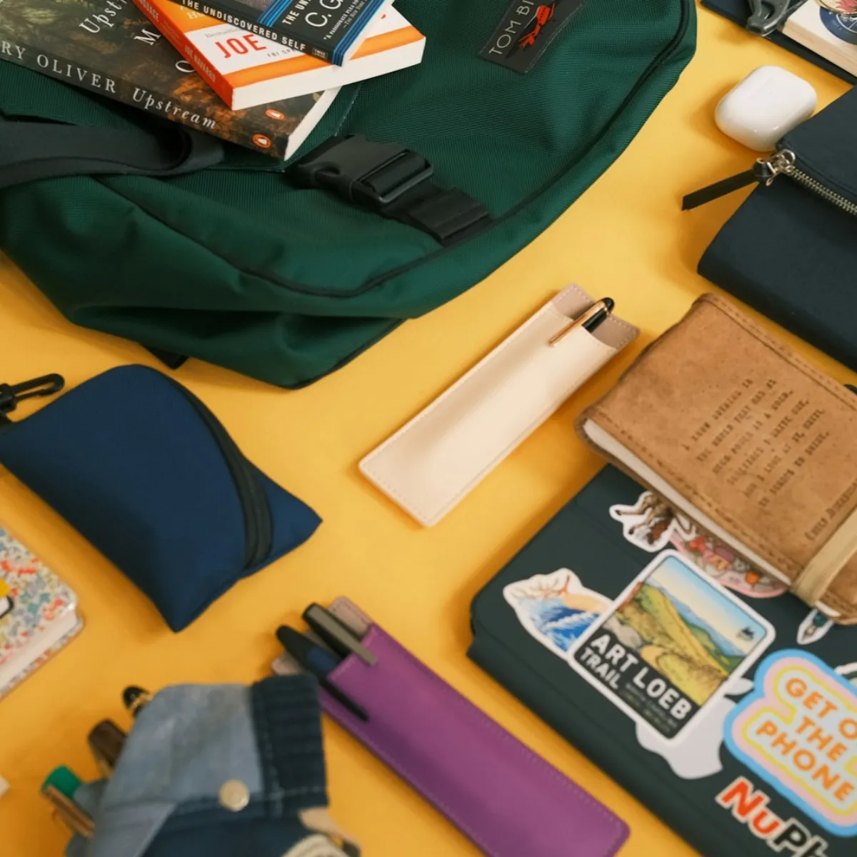 Flat lay of a travel backpack with its contents – clothes, gear, and travel essentials – laid out on a table