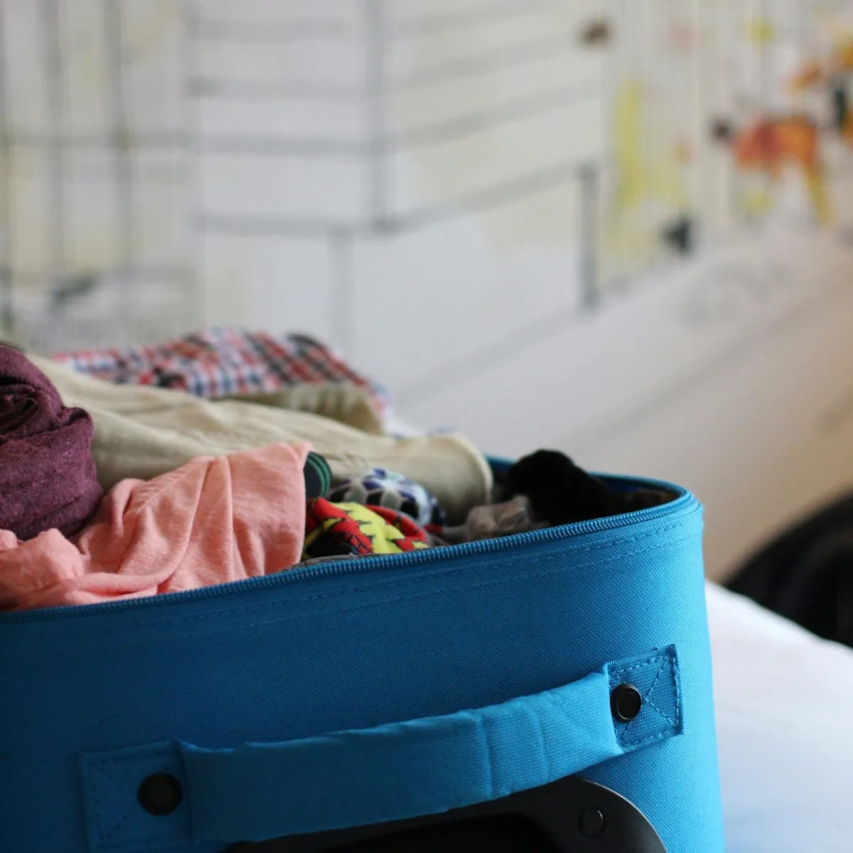 An open suitcase tightly packed with rolled clothes showing how rolling compresses garments and saves space in a carry-on