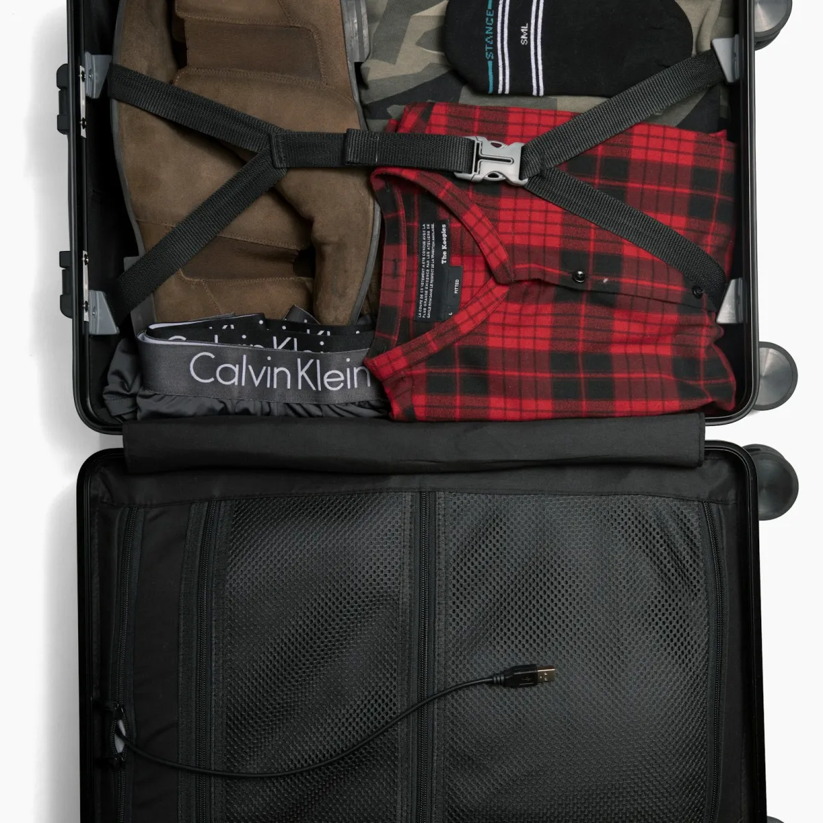 Open suitcase packed with folded clothes ready to be measured for airline size limits