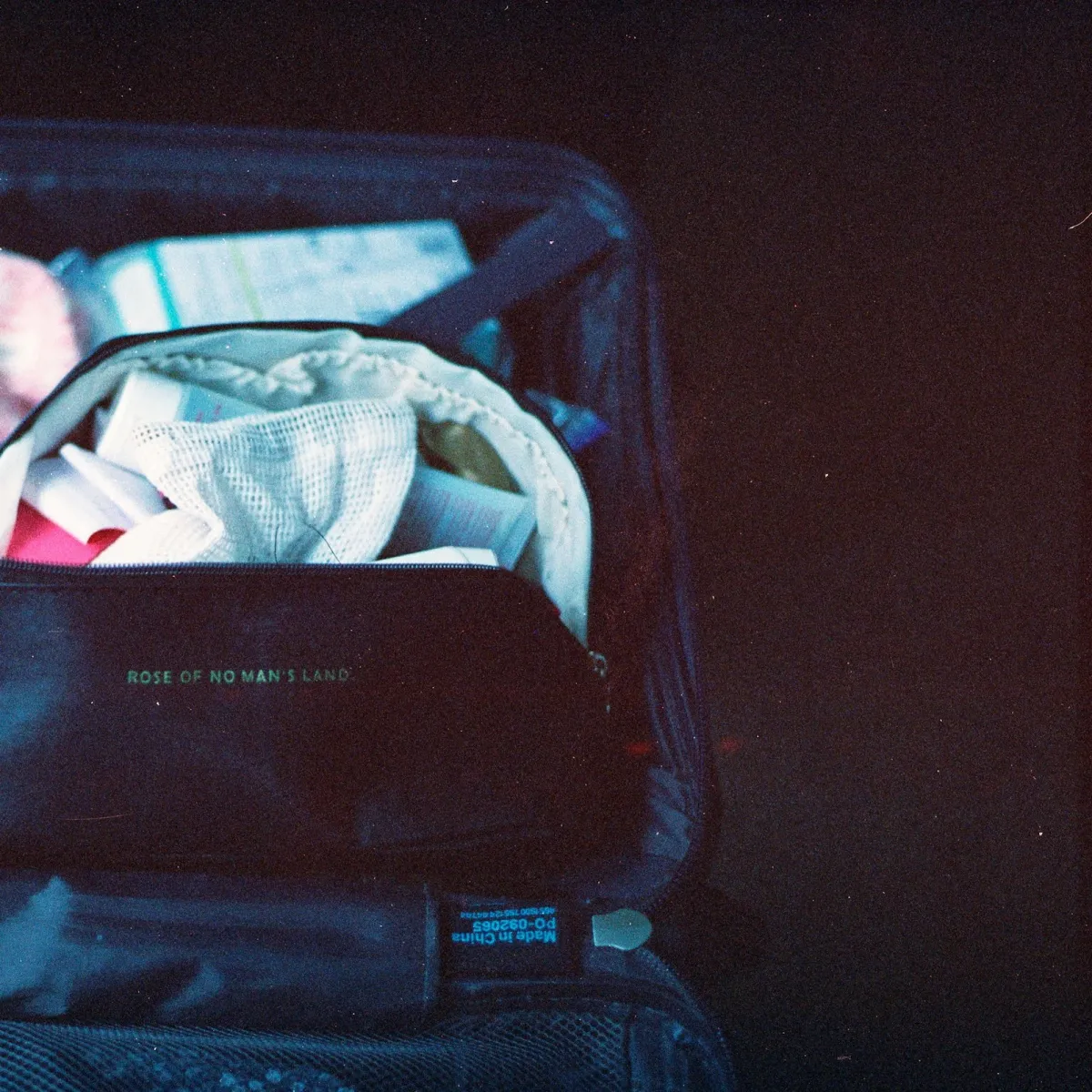 Neatly packed open suitcase with folded clothes and travel toiletries arranged for a trip