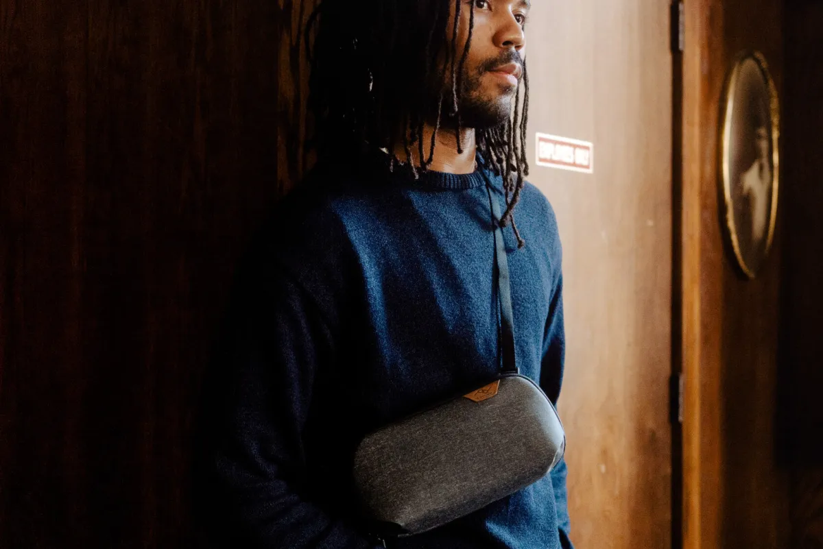 Peak Design Tech Pouch attached to a shoulder strap and worn as a crossbody sling