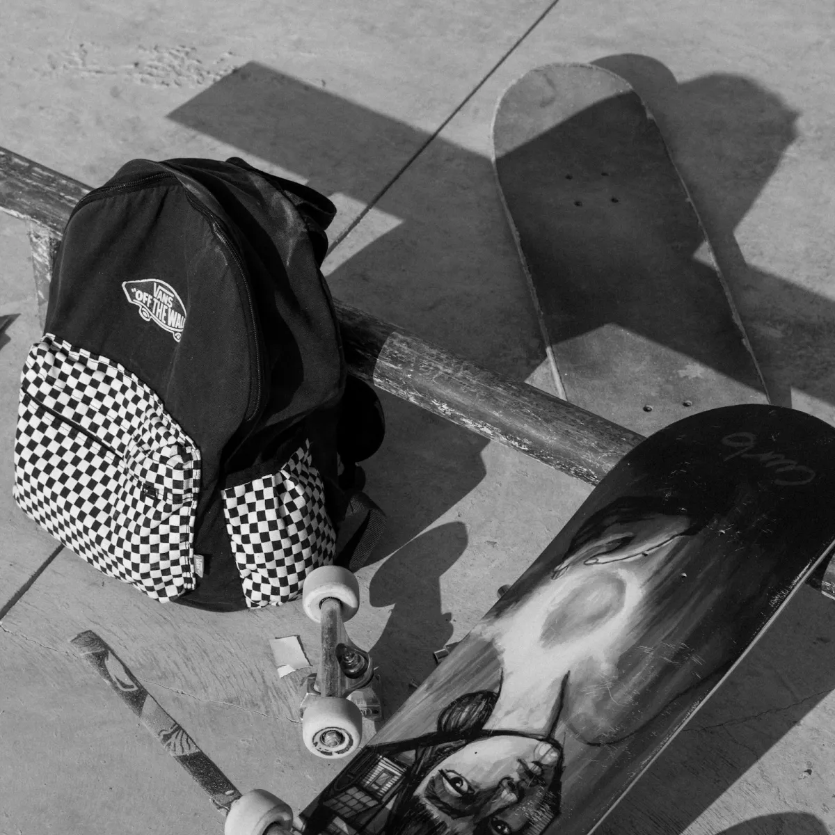 Patterned backpack set down next to a skateboard on a city ledge