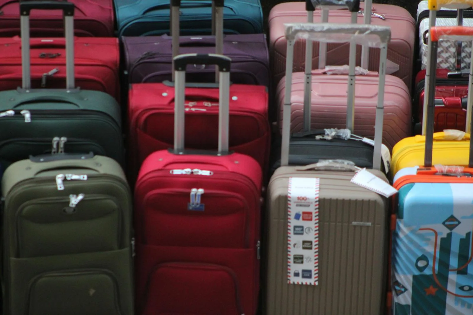 A vibrant collection of various suitcases stacked in preparation for travel
