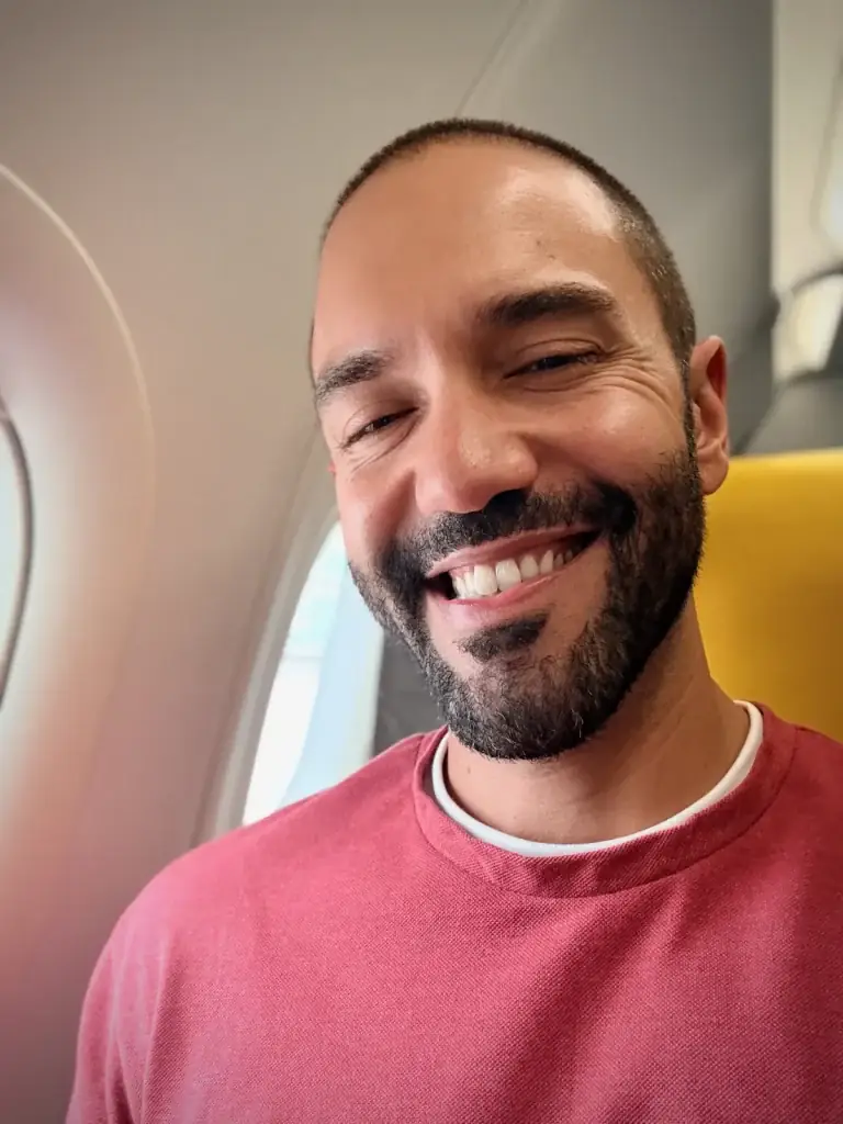 Robert Lora smiling in an airplane window seat