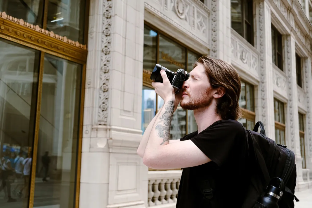 Photographer shooting outside a historic city building with a small backpack on
