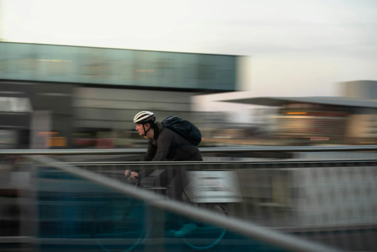 Cyclist crossing a bridge with a commuter bag