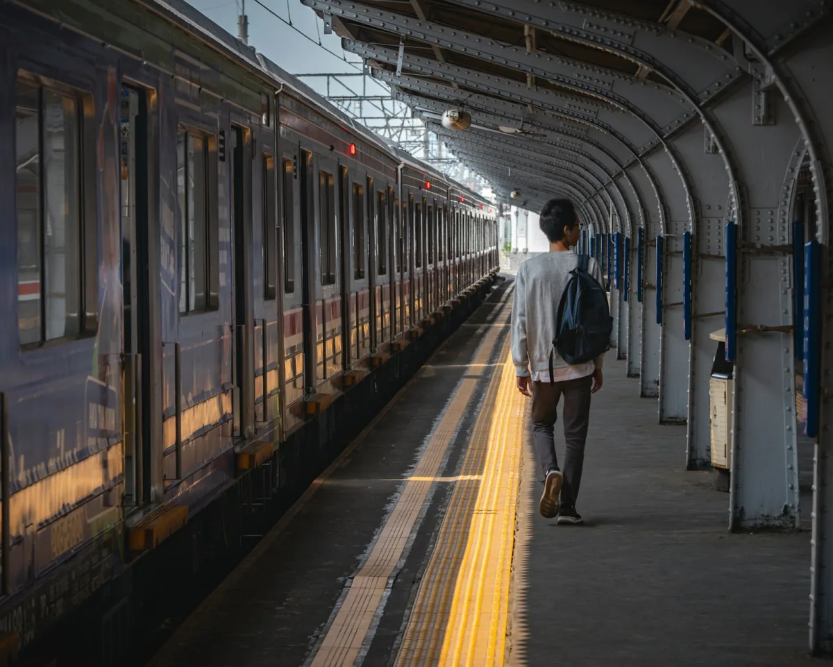 Walking a train platform at sunrise with a bag