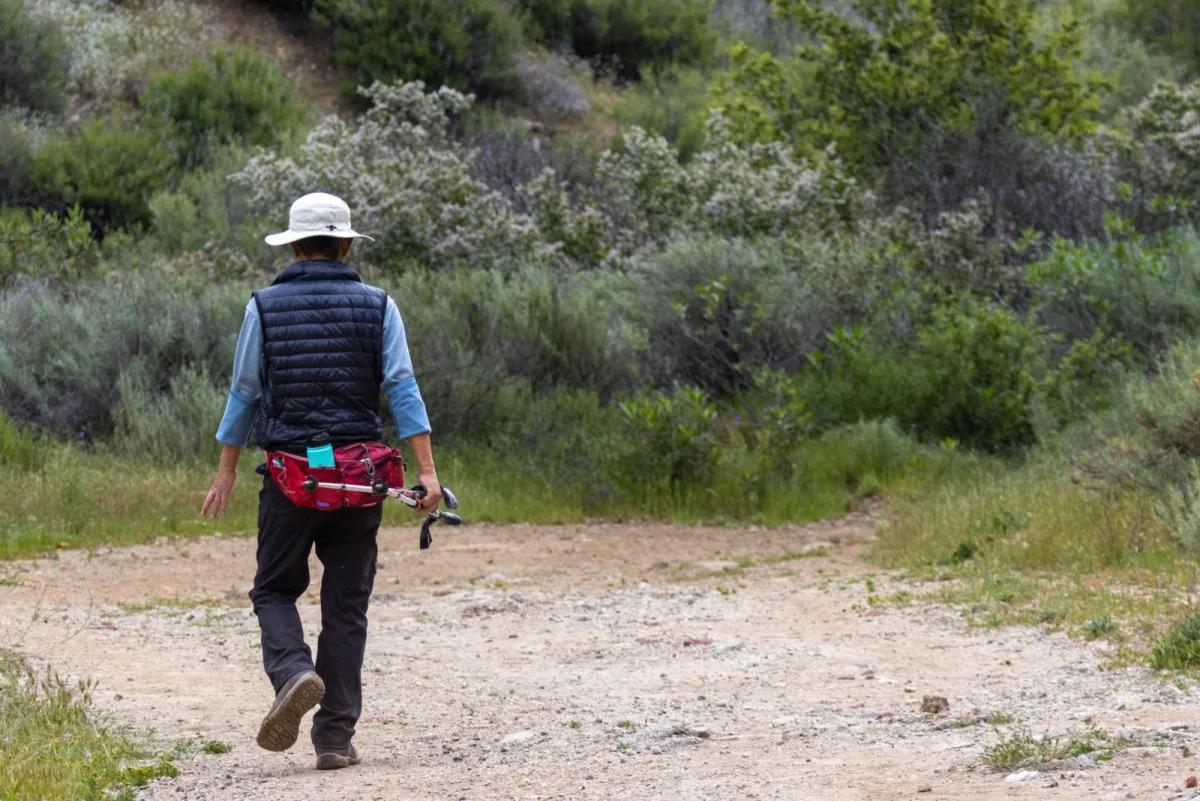 Walker on an open country trail carrying a small day pack