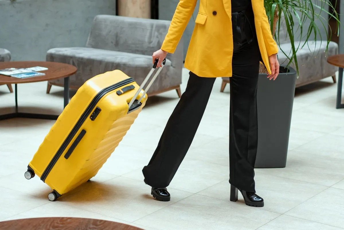 Traveler pulling a hardside carry-on roller through a hotel lobby
