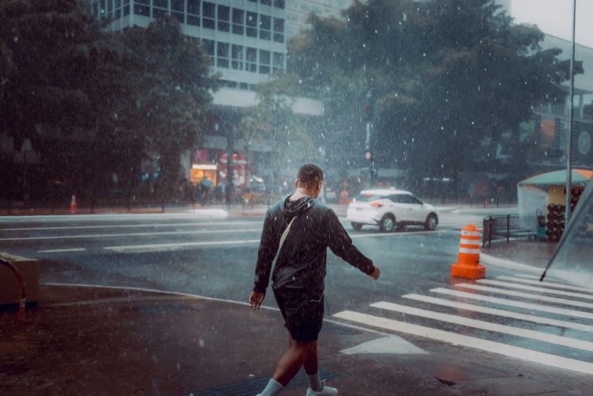 Crossing a city street in steady rain