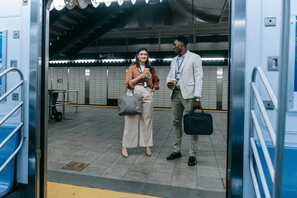 Two professionals with bags at a modern station entrance