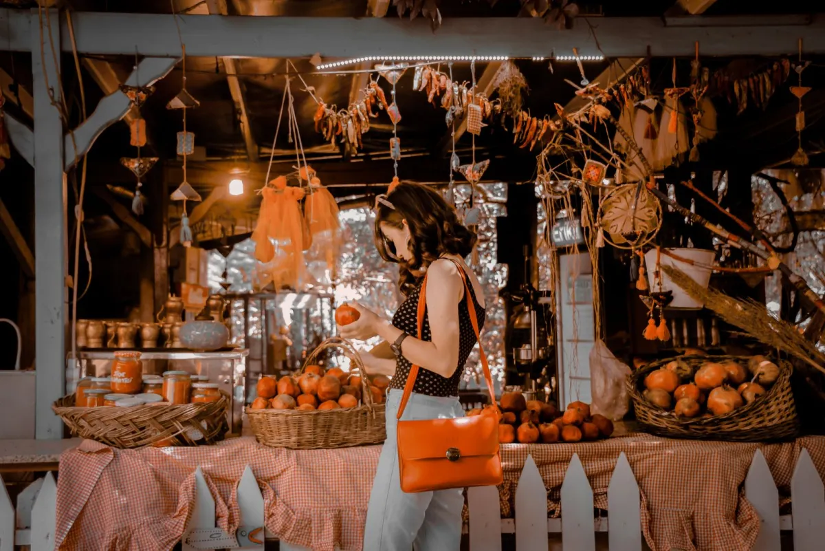 Woman wearing a compact crossbody bag at an outdoor market