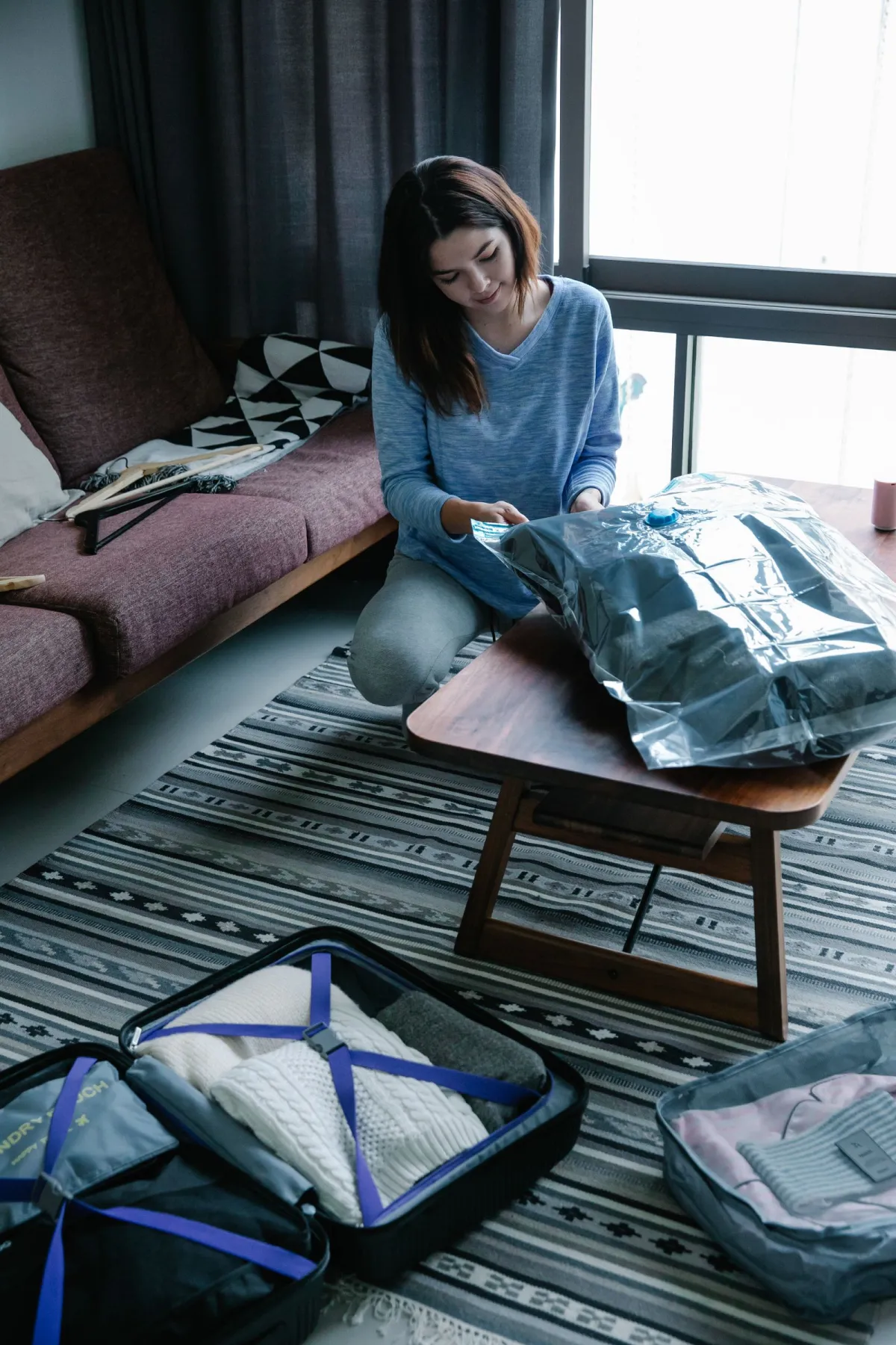 Vacuum compression bag on a table beside an open packed suitcase