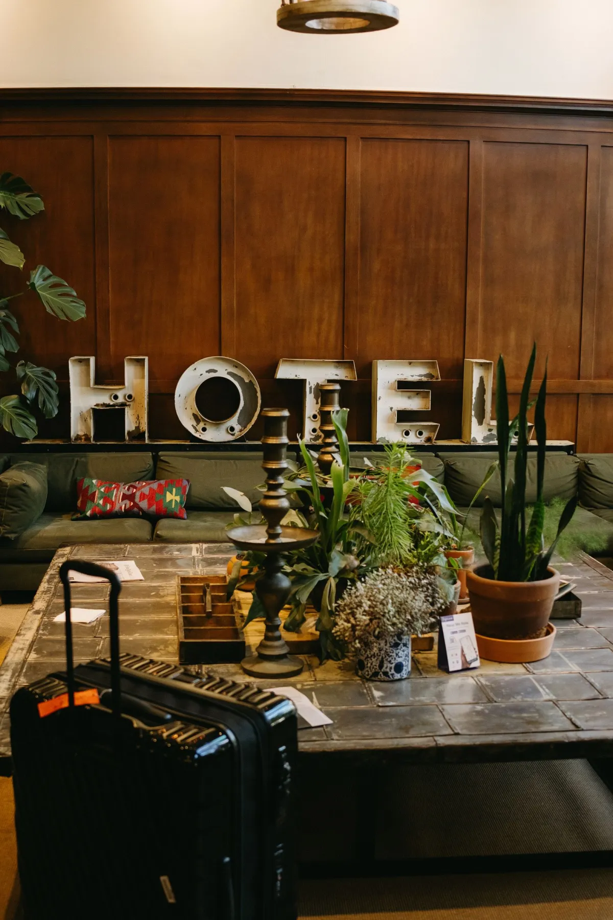 Black rolling carry-on parked in a hotel lobby