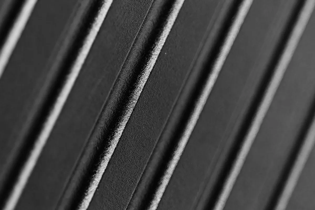 Close view of a grooved black hardside suitcase shell