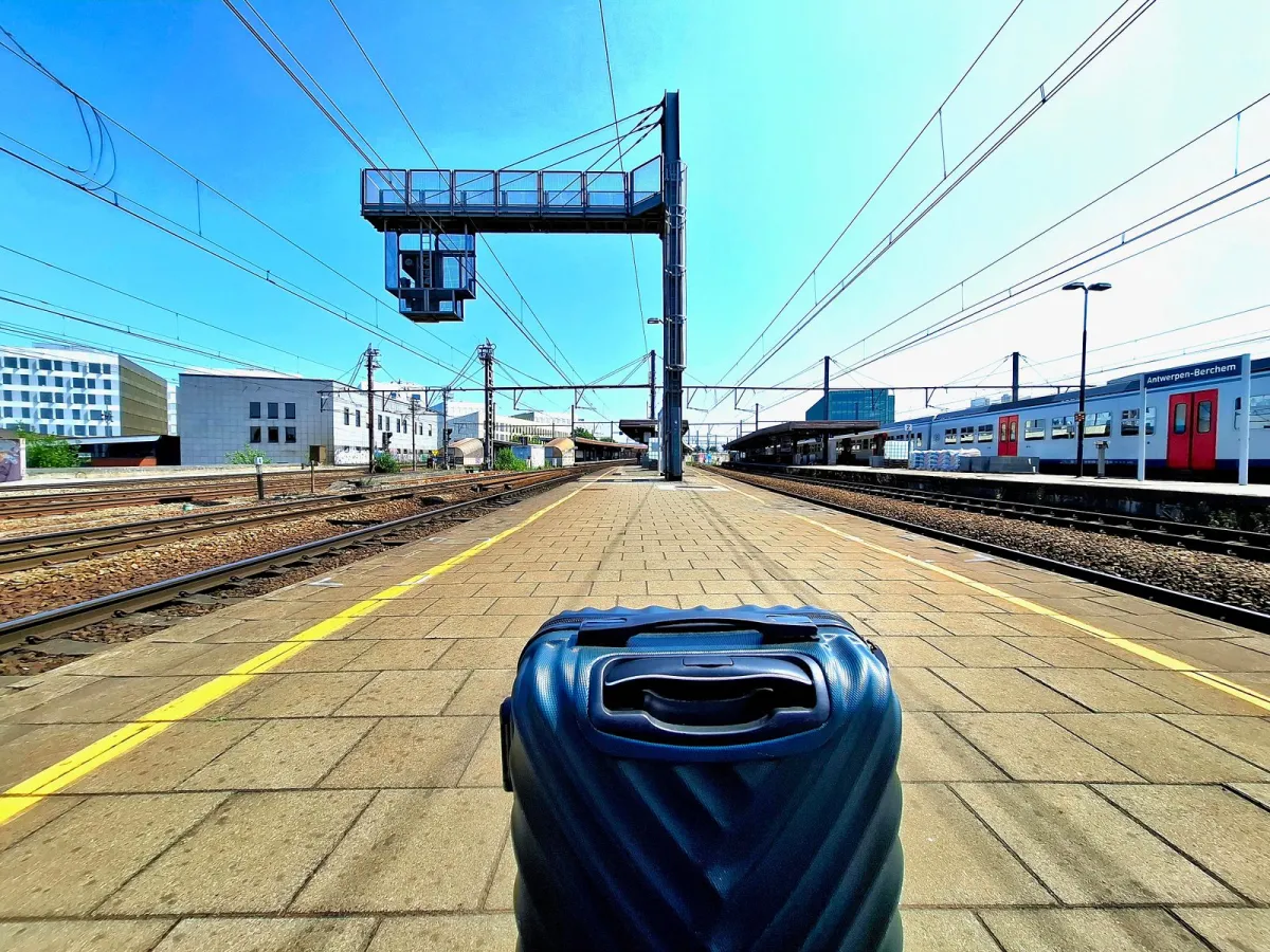 Compact hardside carry-on standing on a train platform